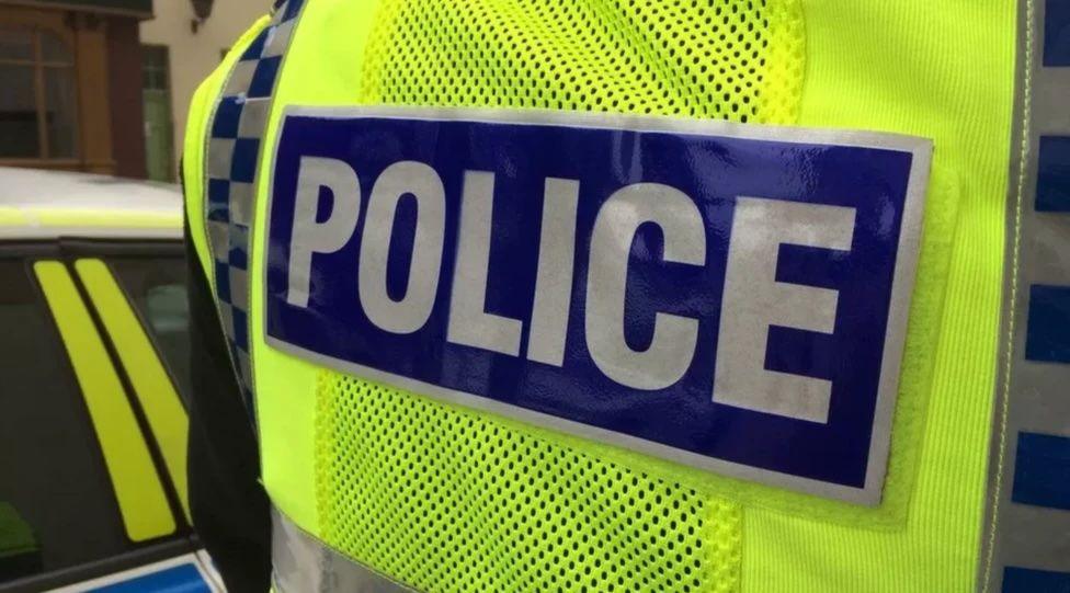 A police hi-vis jacket with the word police in white on a blue background.