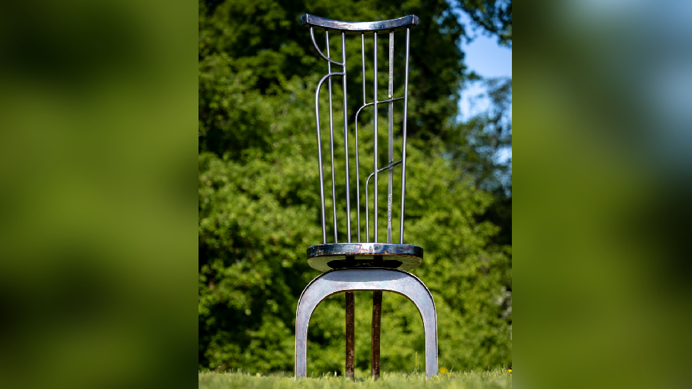 A steel chair in the middle of a field