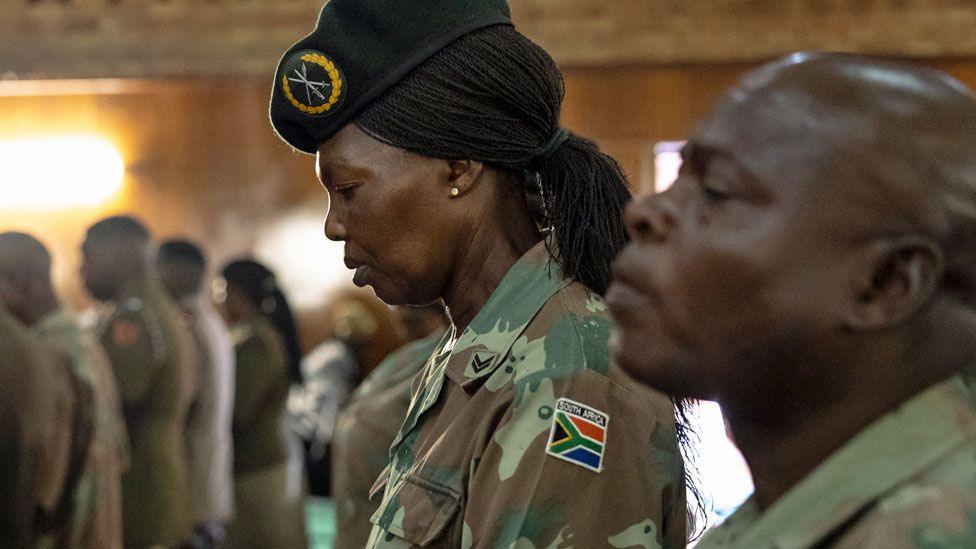 A South African soldier bows her head at a funeral in Pretoria of a colleague killed during a mortar incident in DR Congo - March 2024