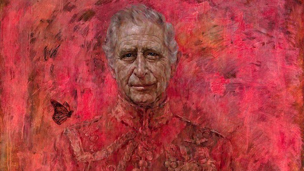 The top third of artist Jonathan Yeo's portrait of King Charles. Charles wears a ceremonial military uniform and a butterfly hovers above his left shoulder, as we look at the painting. The King appears against a striking red background and stares out from the portrait. 
