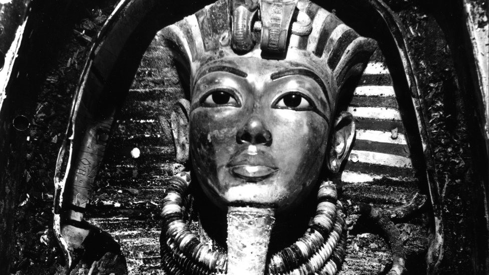 A black and white image of the iconic burial mask of Tutankhamun.