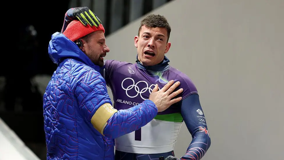 Matt Weston and Martins Dukurs hug