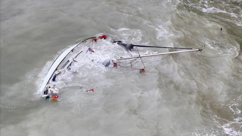 A vessel on sides side in grey sea at Seaford