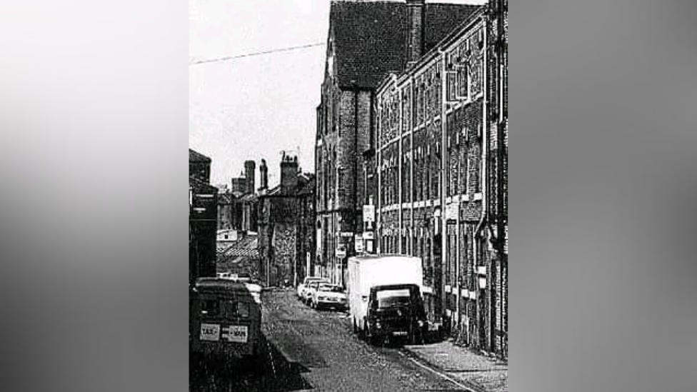 A grainy black-and-white photo of a Manchester street more than 50 years ago.