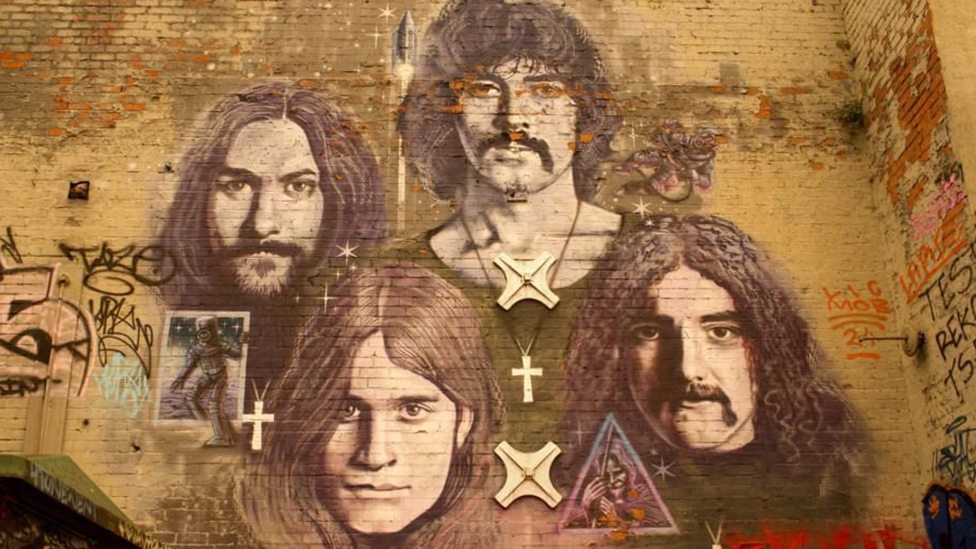 A mural on a brick wall of Black Sabbath band members