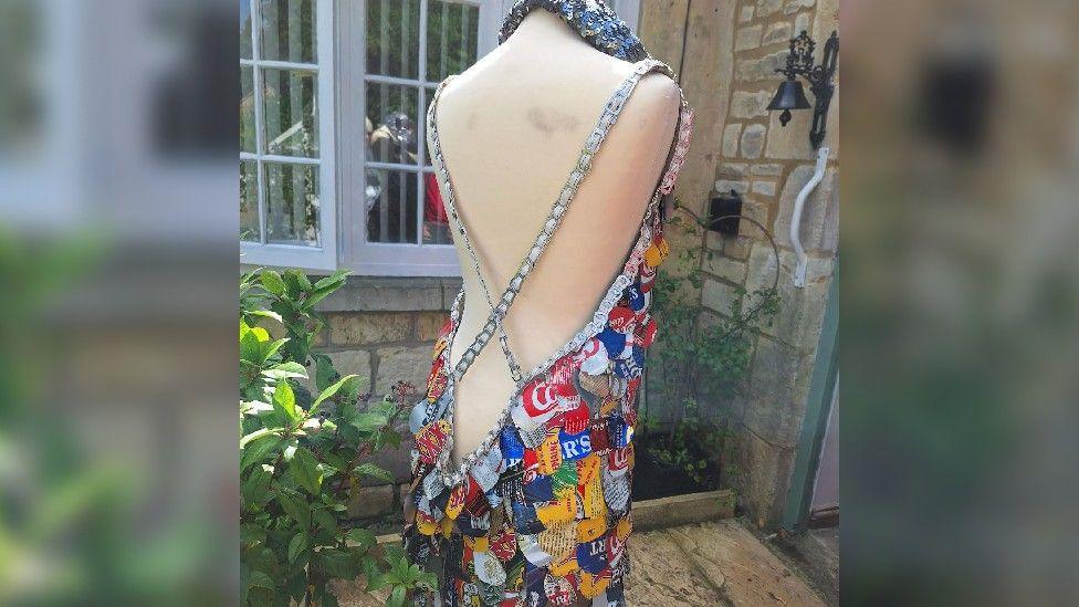 Open-backed dress made from different pieces of drinks containers. The straps are made from the pull-rings from aluminium cans, with a string woven through.