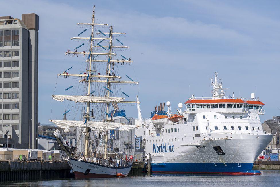 Tall ship in Aberdeen, with a white NorthLink ferry alongside, in Aberdeen harbour.