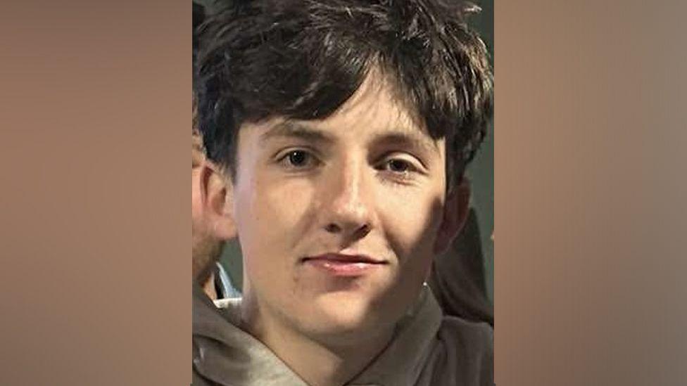 Close up of Ryan Satterthwaite, smiling at camera with short brown hair