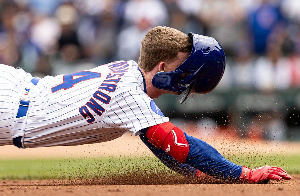 Pete Crow-Armstrong of the Chicago Cubs has his helmet fall and obscure his view as he slides into third base against the Chicago White Sox at Wrigley Field. Photo by Griffin Quinn
