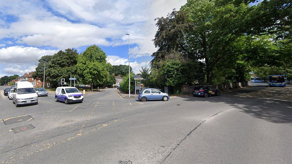 Bargate junction showing a number of cars turning down a tree-lined street