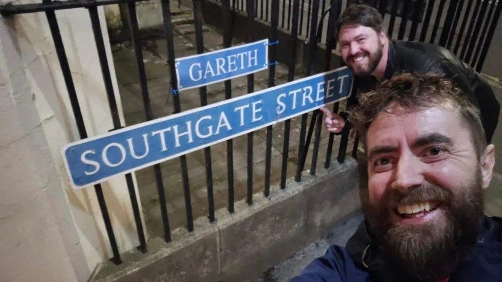 Rich and Tom pose by the 'Gareth' sign that they have positioned above the original Southgate Street sign.