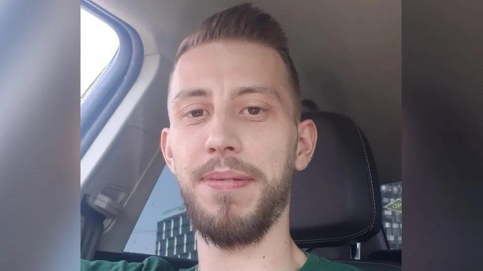 Man with beard sitting in car