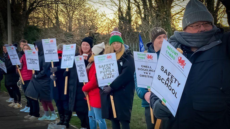 Teachers on a picket line holding signs about school safety in January