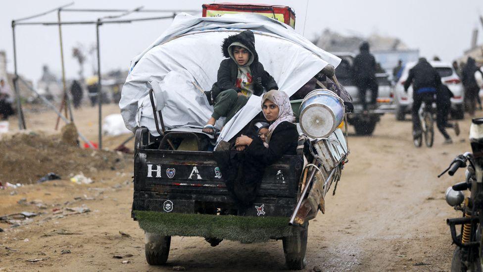 A group of Palestinians ride a cart through debris and destruction in Jabalia, northern Gaza, on 5 February 2025