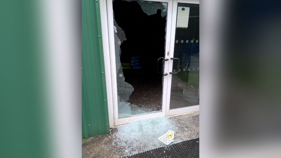 Smashed window door, with significant amounts of smashed up glass on the ground