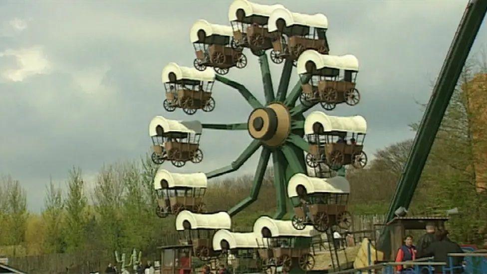 A ferris wheel made up of Oregon Trail style wagons