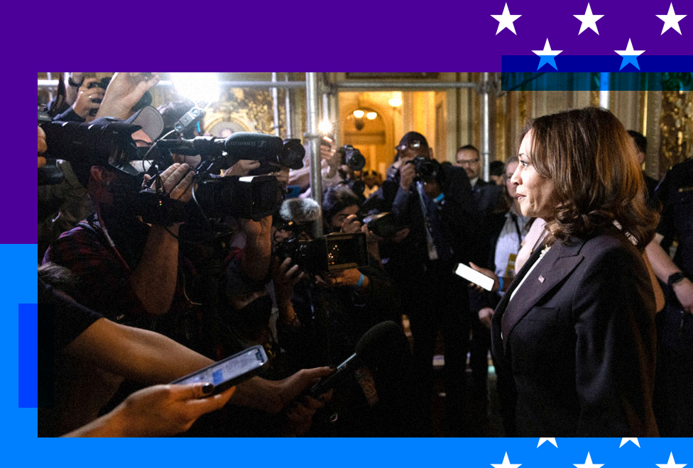 Kamala Harris photographed with a slew of journalists surrounding her 