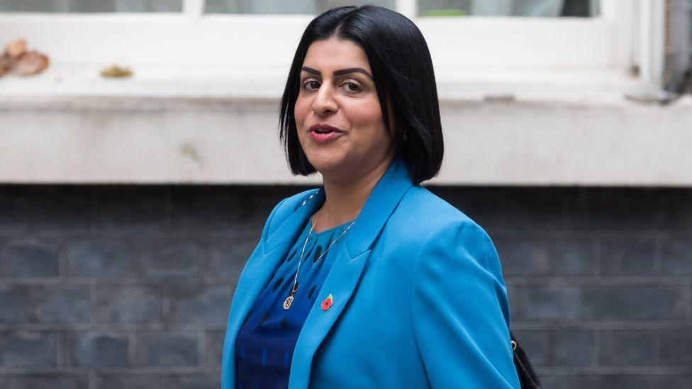  Shabana Mahmood, with dark hair and wearing a blue suit, looks to her left towards the camera as she walks along Downing Street 