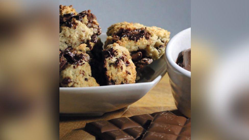 Chocolate chip cookies made out of bread stylishly placed with chocolate laid out next to them