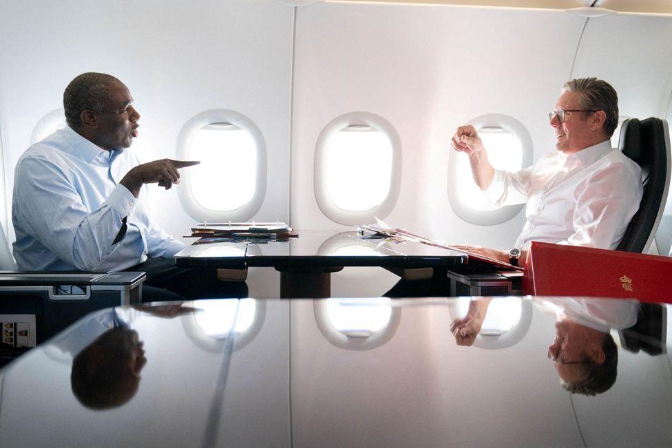 Britain's Prime Minister Keir Starmer and Foreign Secretary David Lammy work on the plane as they fly to the U.S., for talks with President Joe Biden on resolving the conflicts in Ukraine and Gaza,  September 12, 2024.