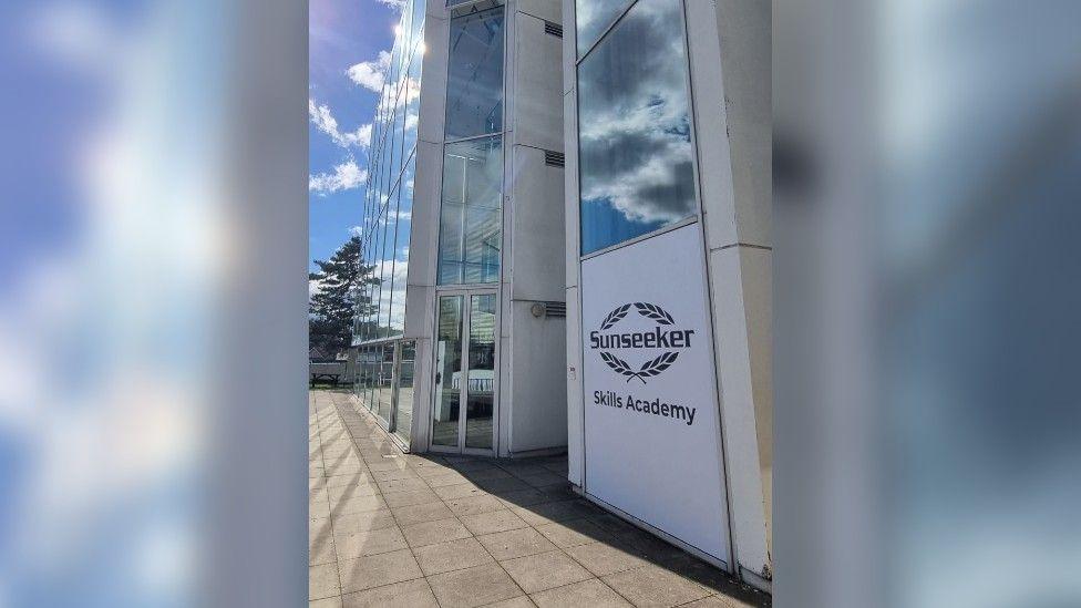 A glass building with a sign reading 'Sunseeker Skills Acadmy'