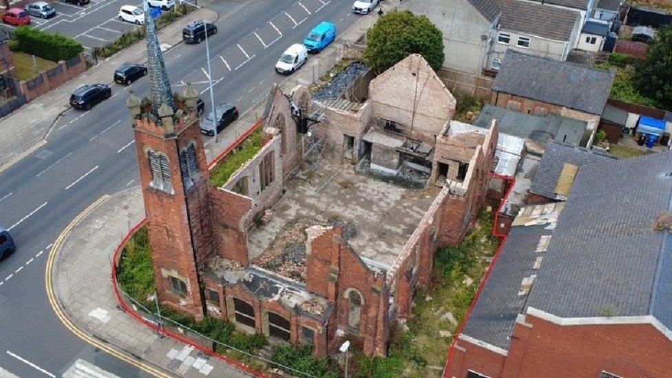 An aerial shot of the church, showing rubble and remains inside the building.