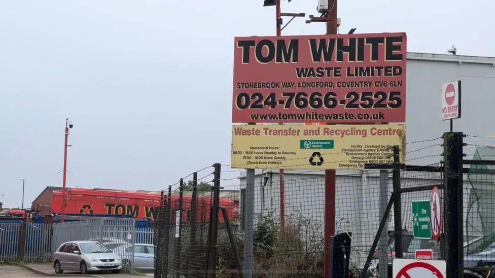 The site of Tom White Waste in Coventry is show with a sign bearing the company's name in the foreground.