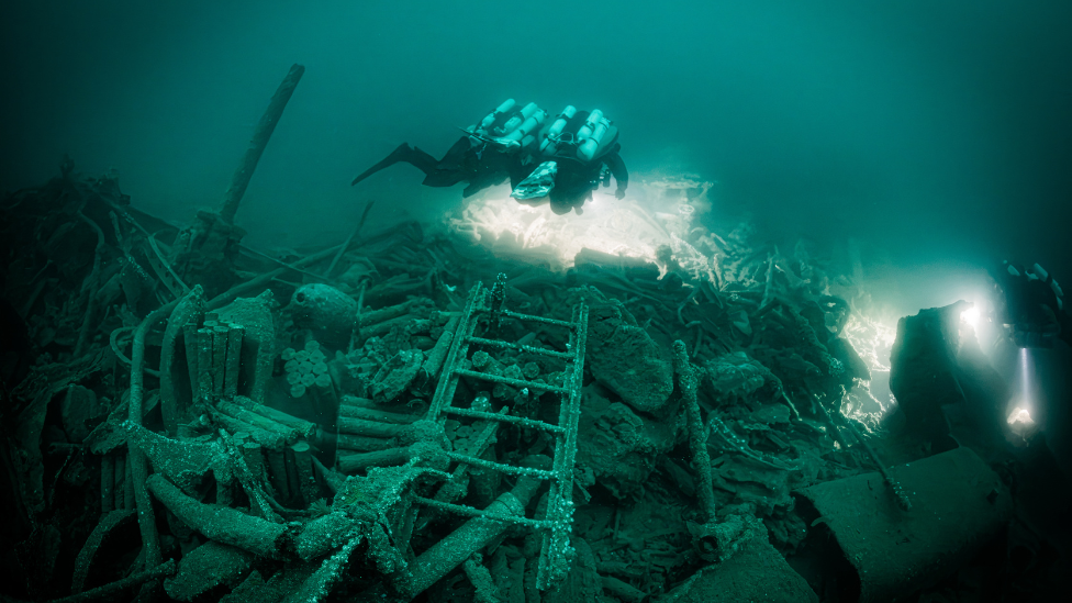 Divers documenting the bow section of the wreck of a Royal Navy warship 