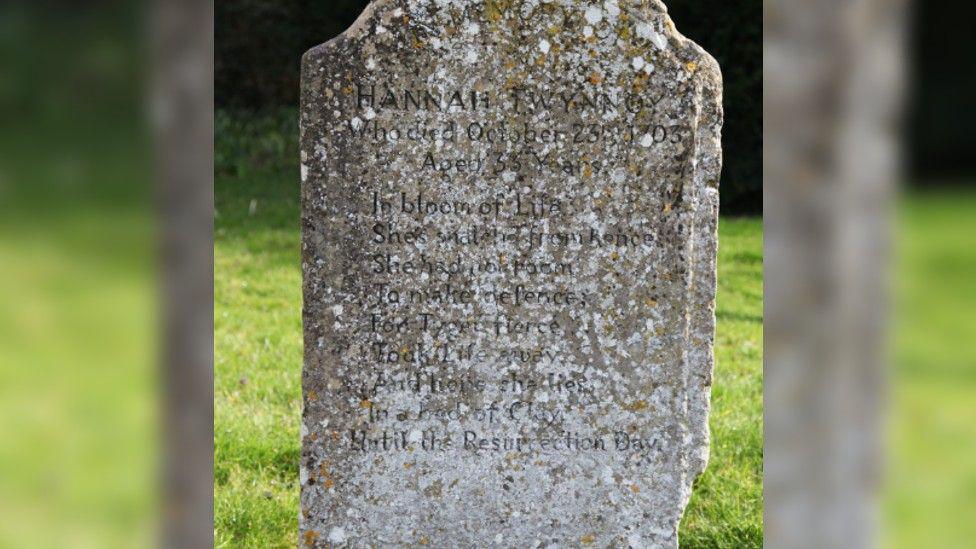 The headstone prior to restoration with lichen blurring the inscription