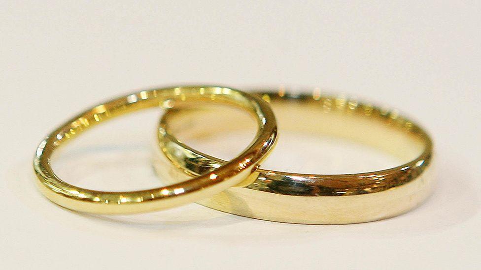 Close up generic image of two gold wedding bands, one resting slightly on top of the other