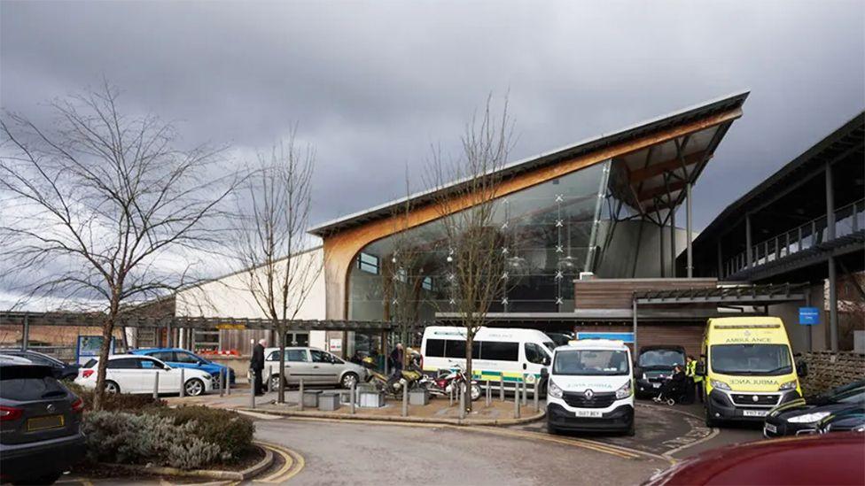 The glass-fronted entrance of the oncology unit at Castle Hill Hospital near Hull with ambulances and cars parked outside 