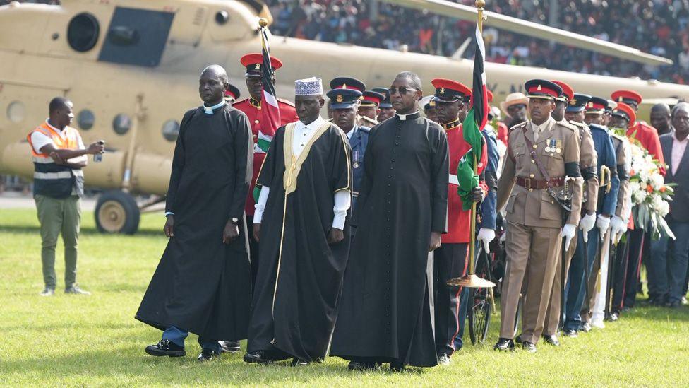 Officials and clergy escort the coffin of Raila Odinga across the stadium in Kisumu.

