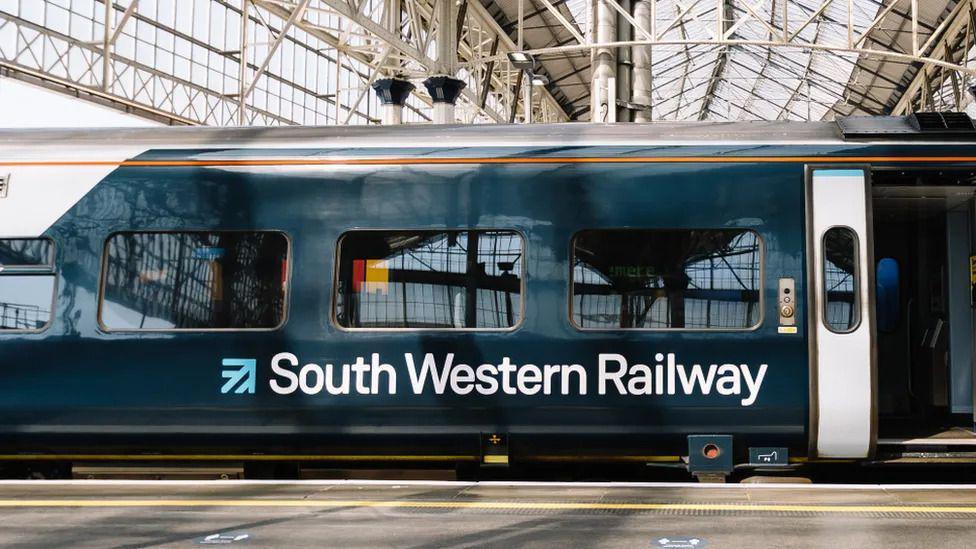 A South Western Railway train at the platform with doors open