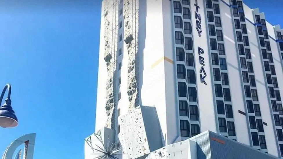 A huge climbing wall on the outside of a hotel. 