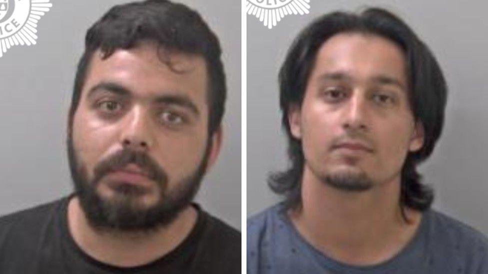 Two mugshots side by side - one man has dark hair and a dark beard, and is wearing a black top, while the other has long black hair and a goatee and is wearing a blue shirt.
