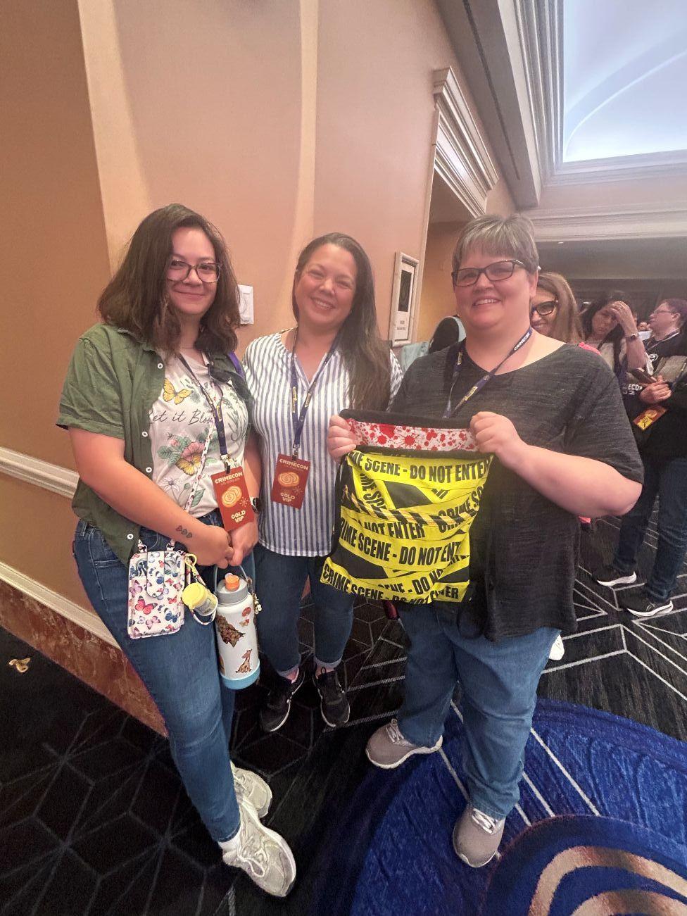Friends hold up their crime-tape and blood-spatter adorned bag