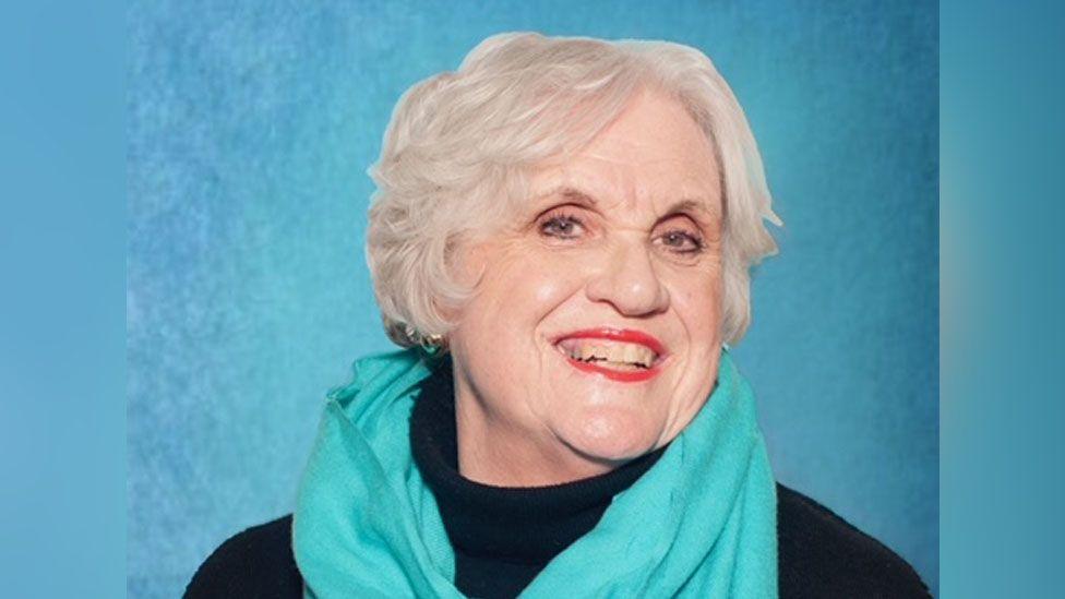 Pamela Walford, in a blue scarf, smiling