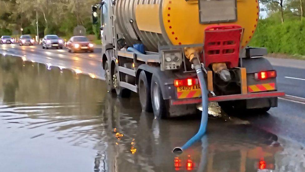 vehicle with blue hose sucking up flood water