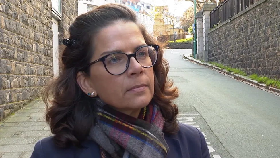 Education President, Deputy Andrea Dudley-Owen, standing in a quiet street, wearing a scarf and jacket