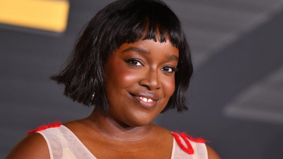 British actress Ololade "Lolly" Adefope attends the LA premiere of HBO's original series The Franchise at the Paramount theatre in Los Angeles in October. She is wearing a white and red sleeveless dress.