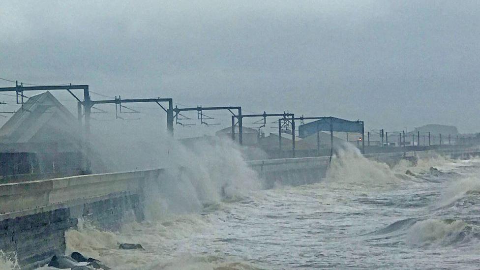 Waves crash up the sea wall, sending spray over the railway line at Saltcoats in Ayrshire