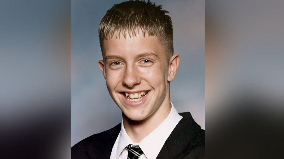 A school picture of Chris Cave. A young man, with short brown hair, who is smiling.