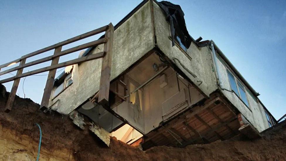 A picture from 2013 of Bryony Nierop-Reading's home hanging over the top of a cliff edge. 