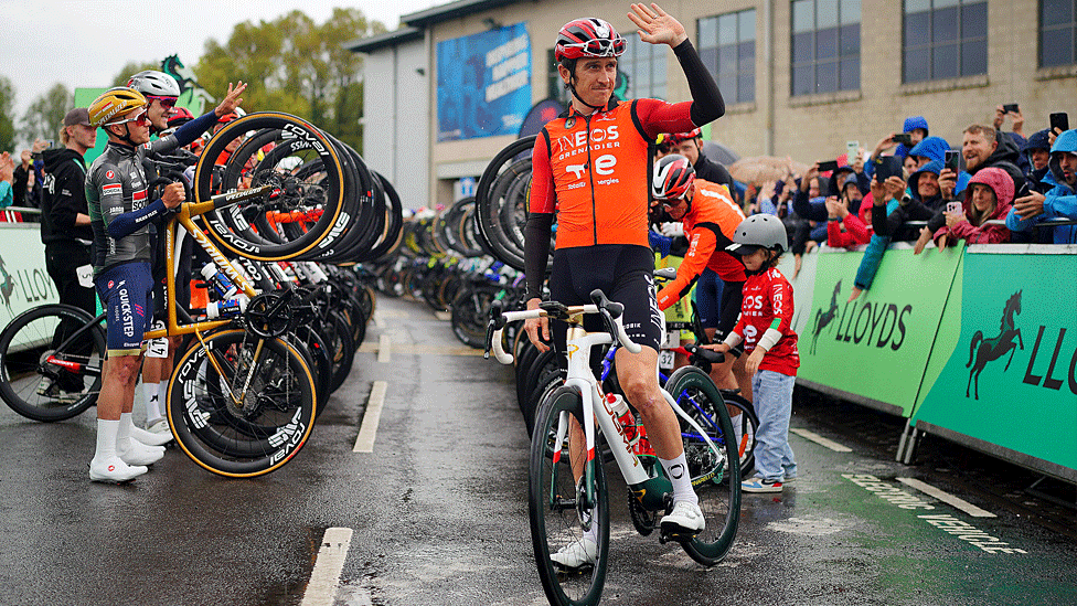Seiclwyr proffesiynol mewn rhes yn dal teiars blaen eu beiciau yn yr awyr er mwyn talu teyrnged i Geraint Thomas