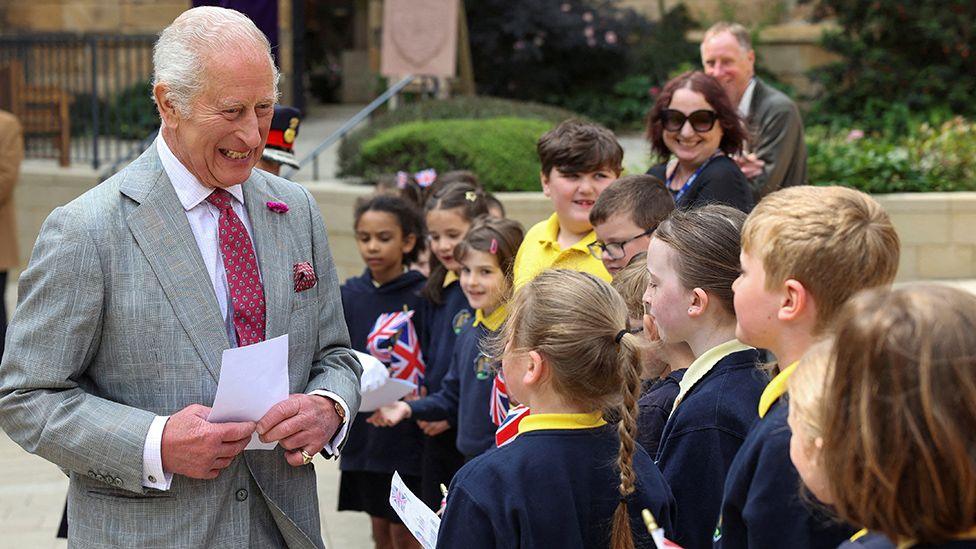 Pupils from Willow Lane Primary School lined up meeting a smiling King Charles