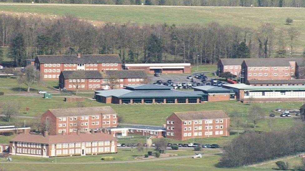 An aerial image showing the military base camp at Larkhill in Wiltshire. It is a large complex of brown brick buildings surrounded by fields and trees.