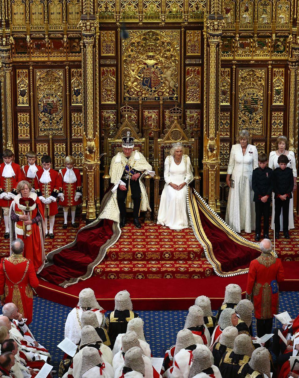 King Charles III, wearing the Imperial State Crown and the Robe of State, sits alongside Queen Camilla before reading the King's Speech from the Sovereign's Throne in the House of Lords chamber, during the State Opening of Parliament, at the Houses of Parliament, in London