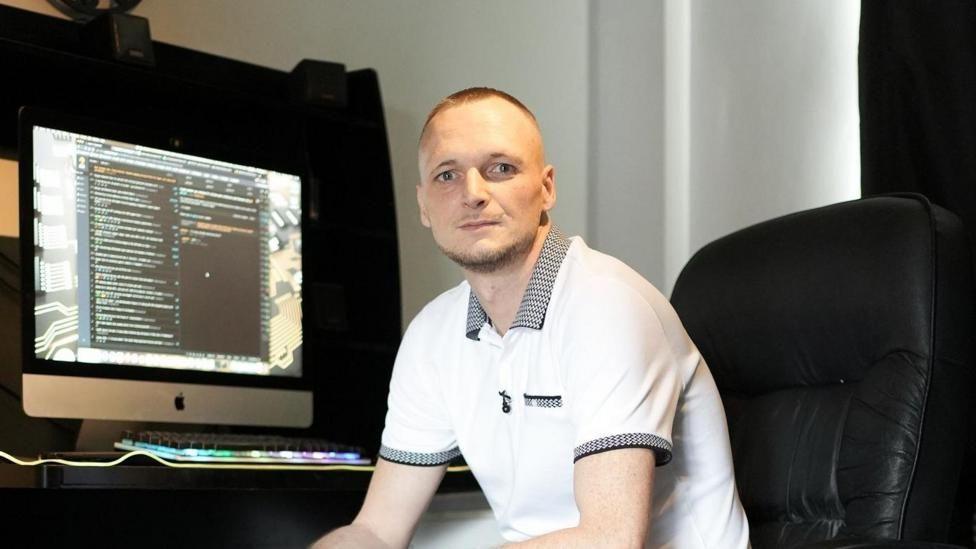 James Howells from Newport sitting in an office chair in front of his computer