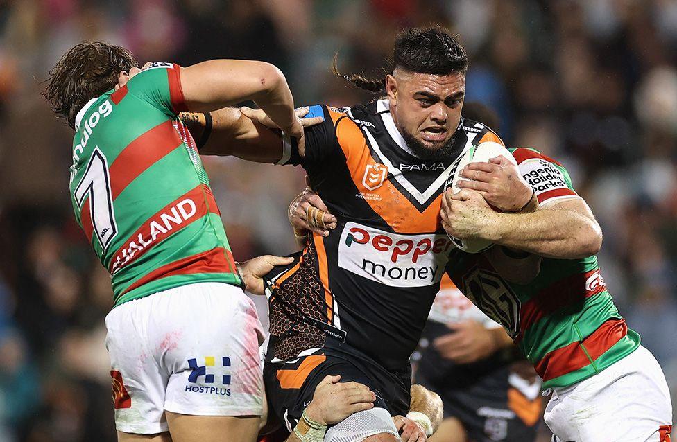 Royce Hunt of Wests Tigers tries to break through three South Sydney Rabbitohs players during an NRL match. Photo by Cameron Spencer