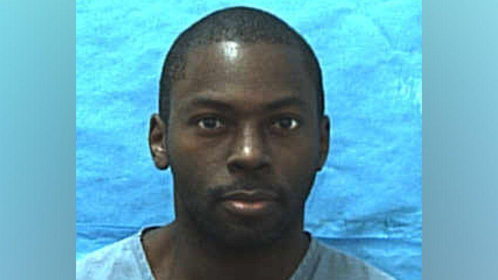 Mugshot of Mark Gordon dated 15 January 2010. He is looking directly into the camera and is wearing a light blue top against a blue background.